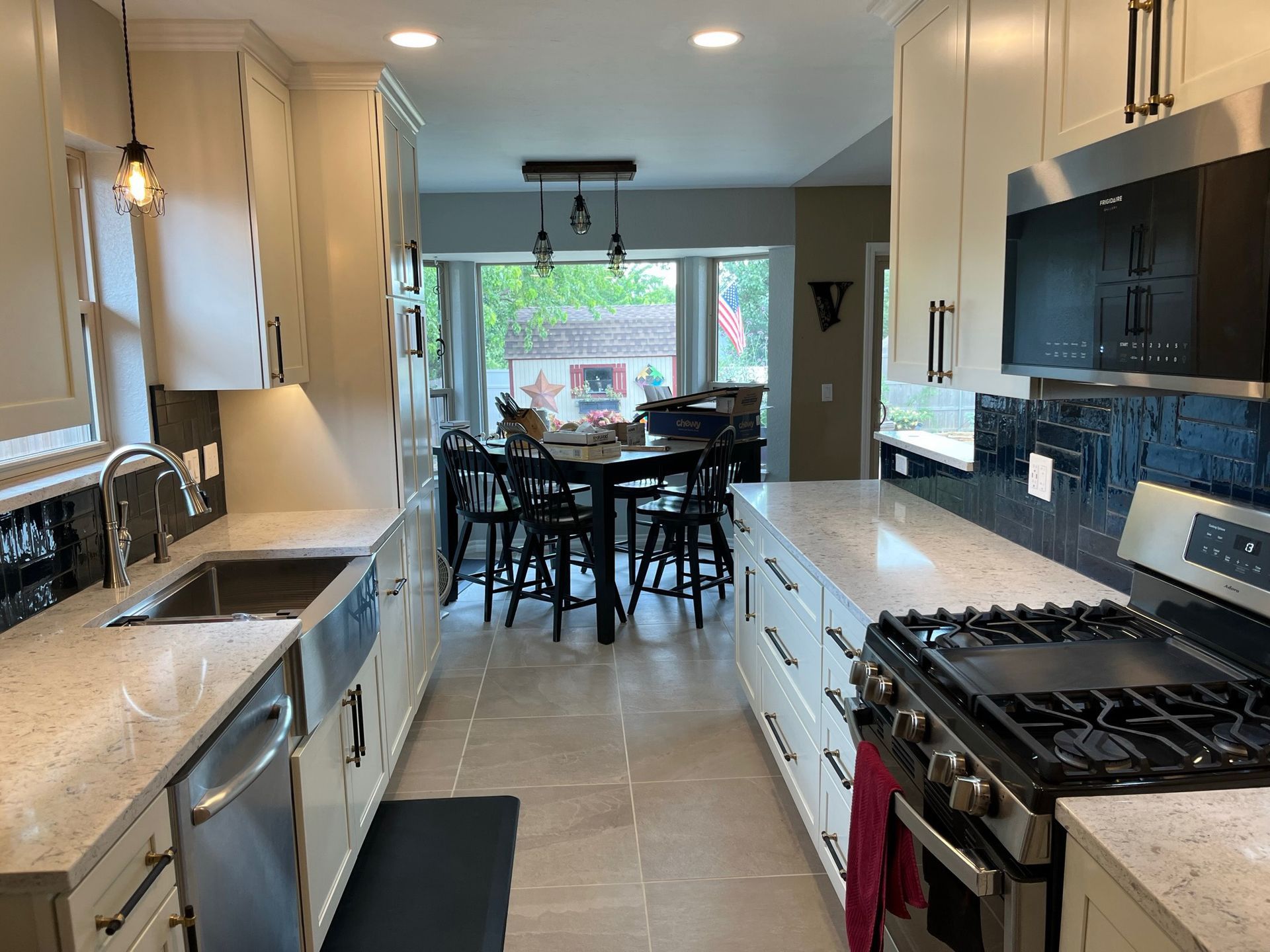Kitchen with light cabinets, countertops, and stainless steel appliances. Dining area with a table and chairs in the background.