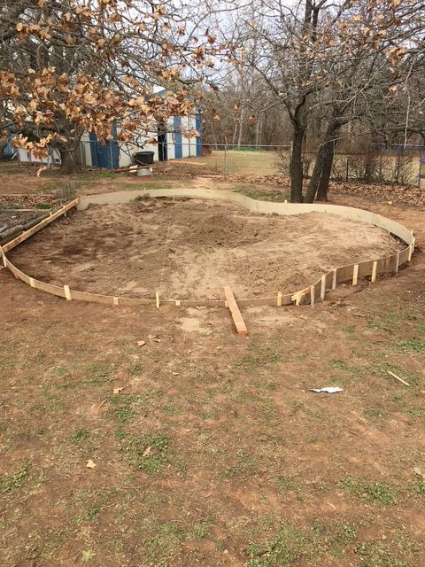 Circular garden bed outline under construction, in a grassy yard.