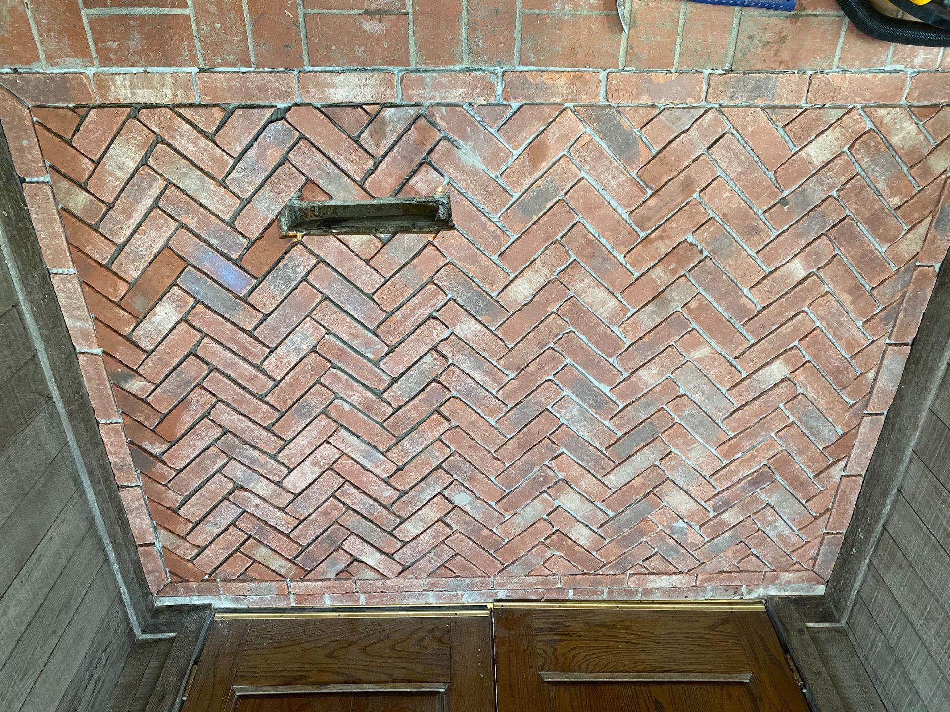 Herringbone brick entrance with a mailbox.