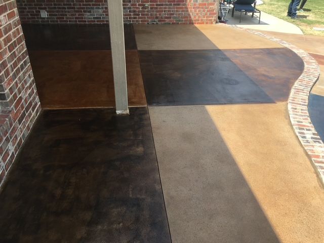 Patio with stained concrete in brown and tan, brick accents, and sunlight.