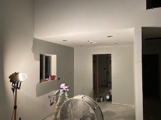 Interior renovation with freshly painted gray walls, a fan, and work light.