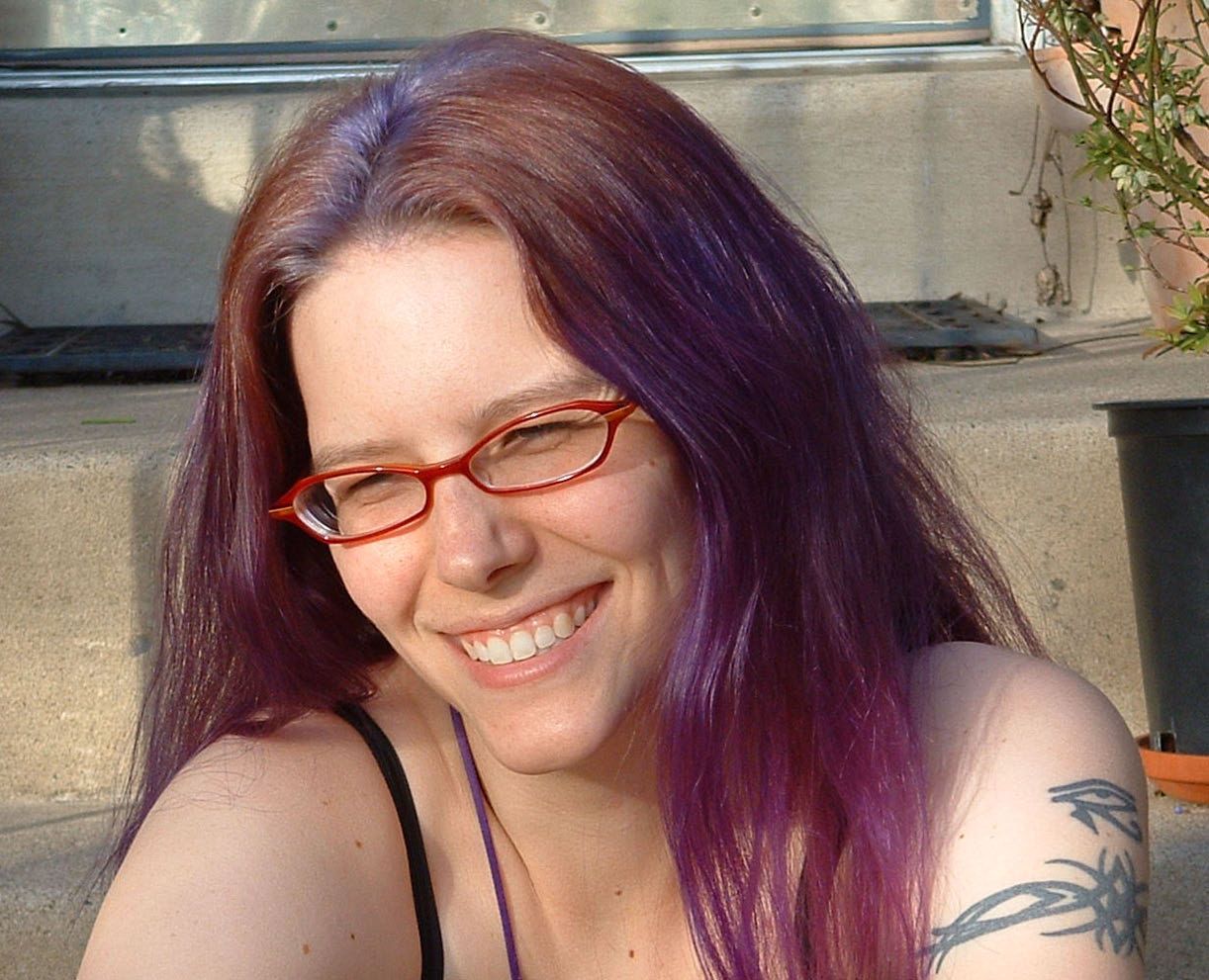 A group of men are standing around looking at a tablet.