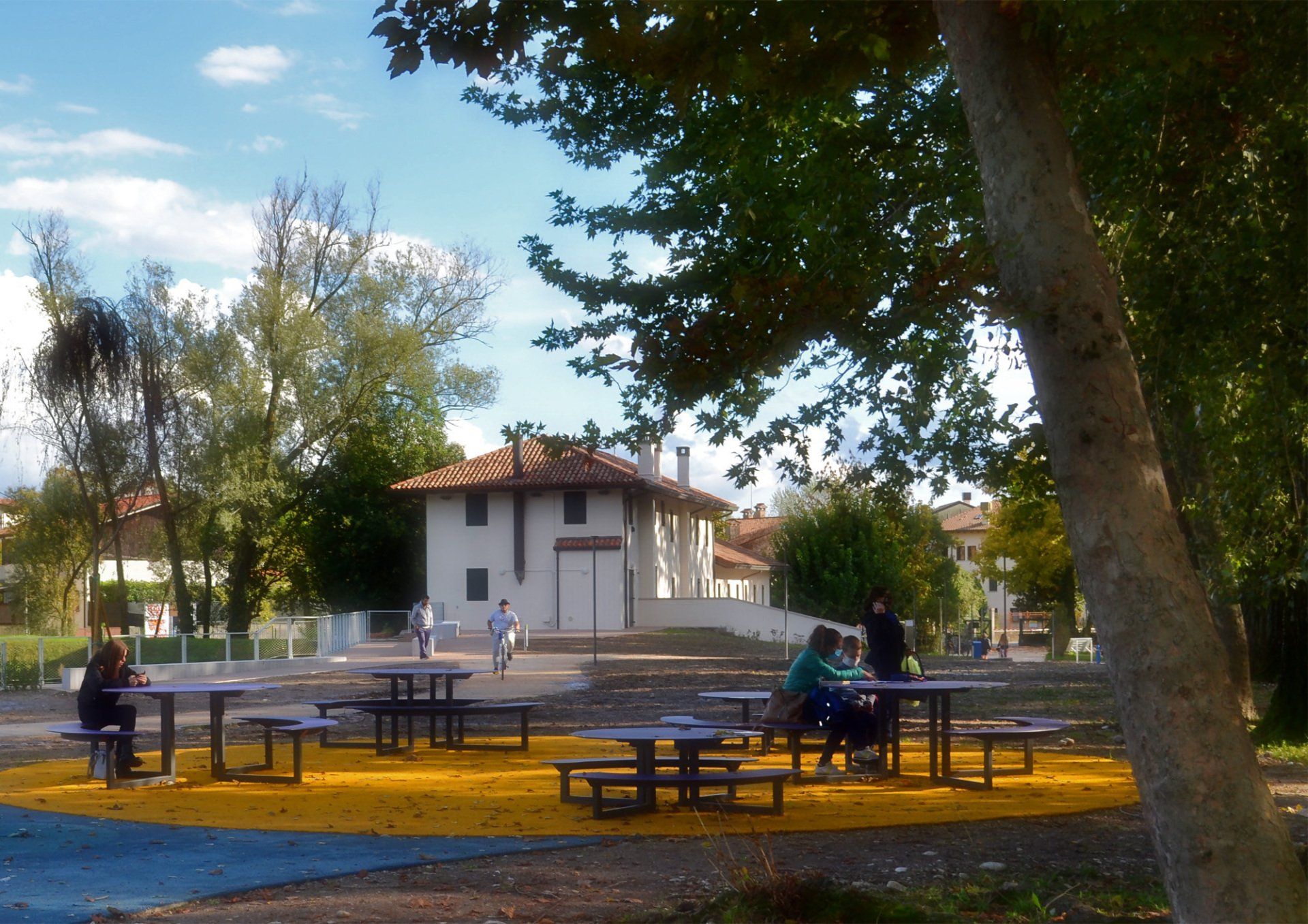 Parco urbano con tavoli e panchine ad altezze diverse per adulti e bambini