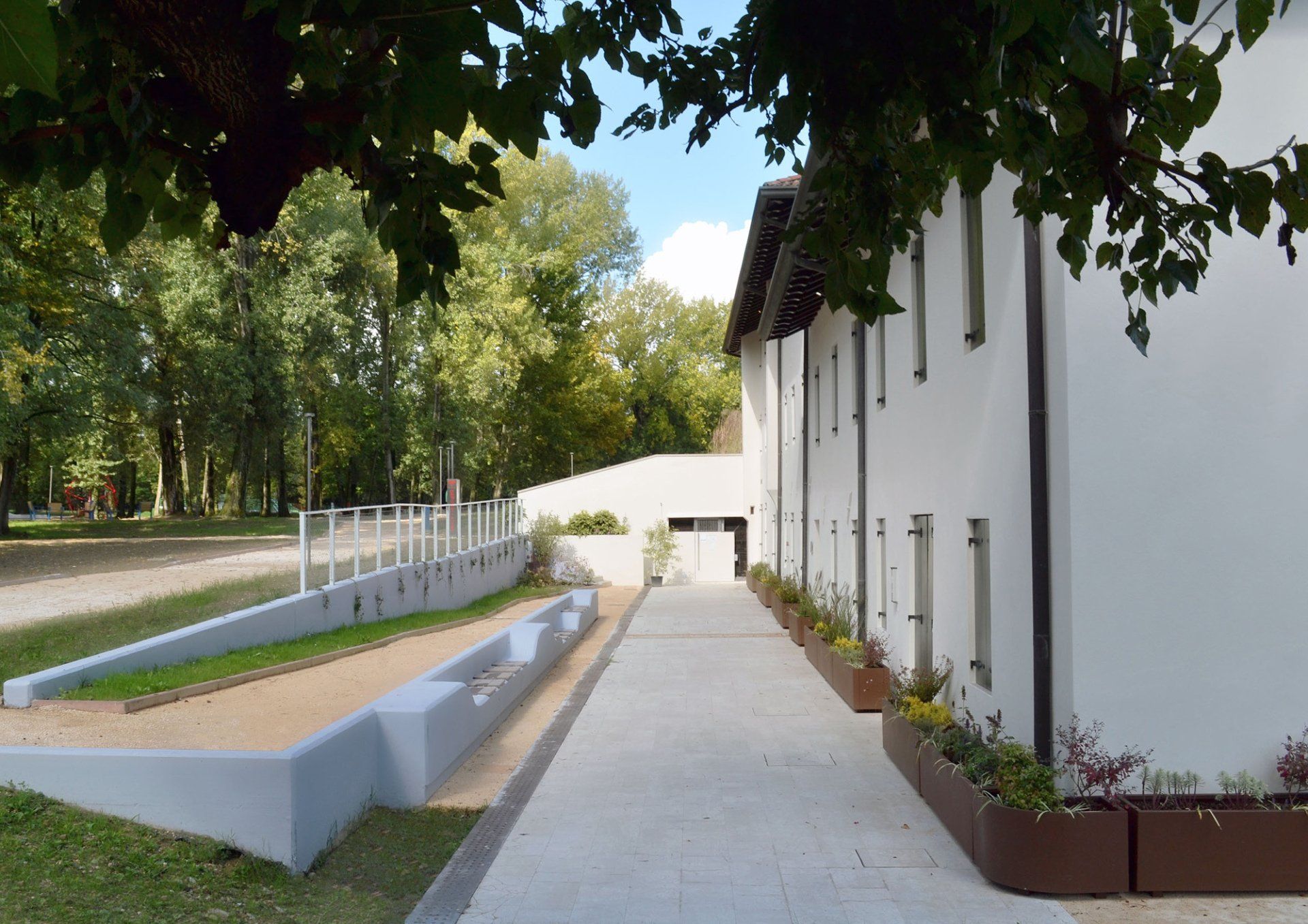 Area pubblica con panchine per adulti e bambini e segnaletica tattilo plantare integrata nella pavimentazione 