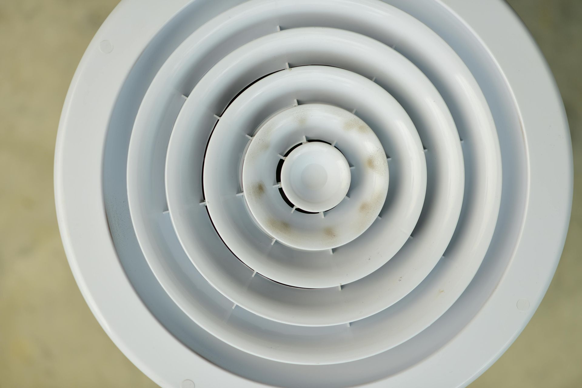 A wall-mounted white wireless router glows with an orange LED frame and Wi-Fi symbol against a textured gray wall.