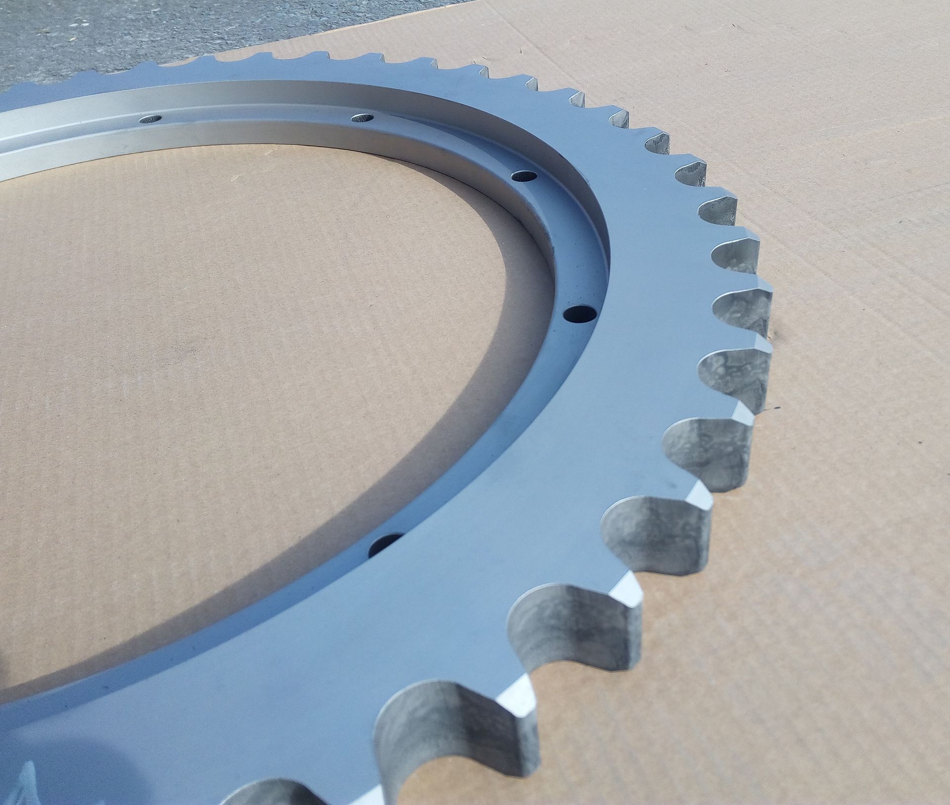 Eine Nahaufnahme eines Metallzahnrads auf einer Kartonoberfläche