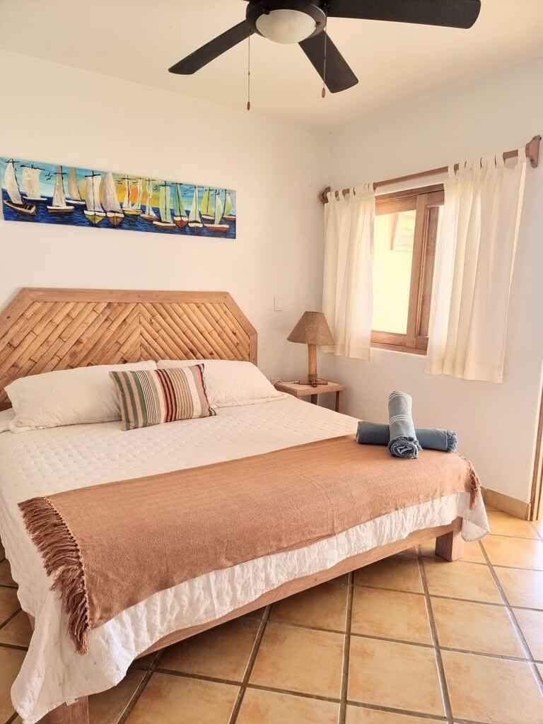 A bedroom with a king size bed and a ceiling fan.