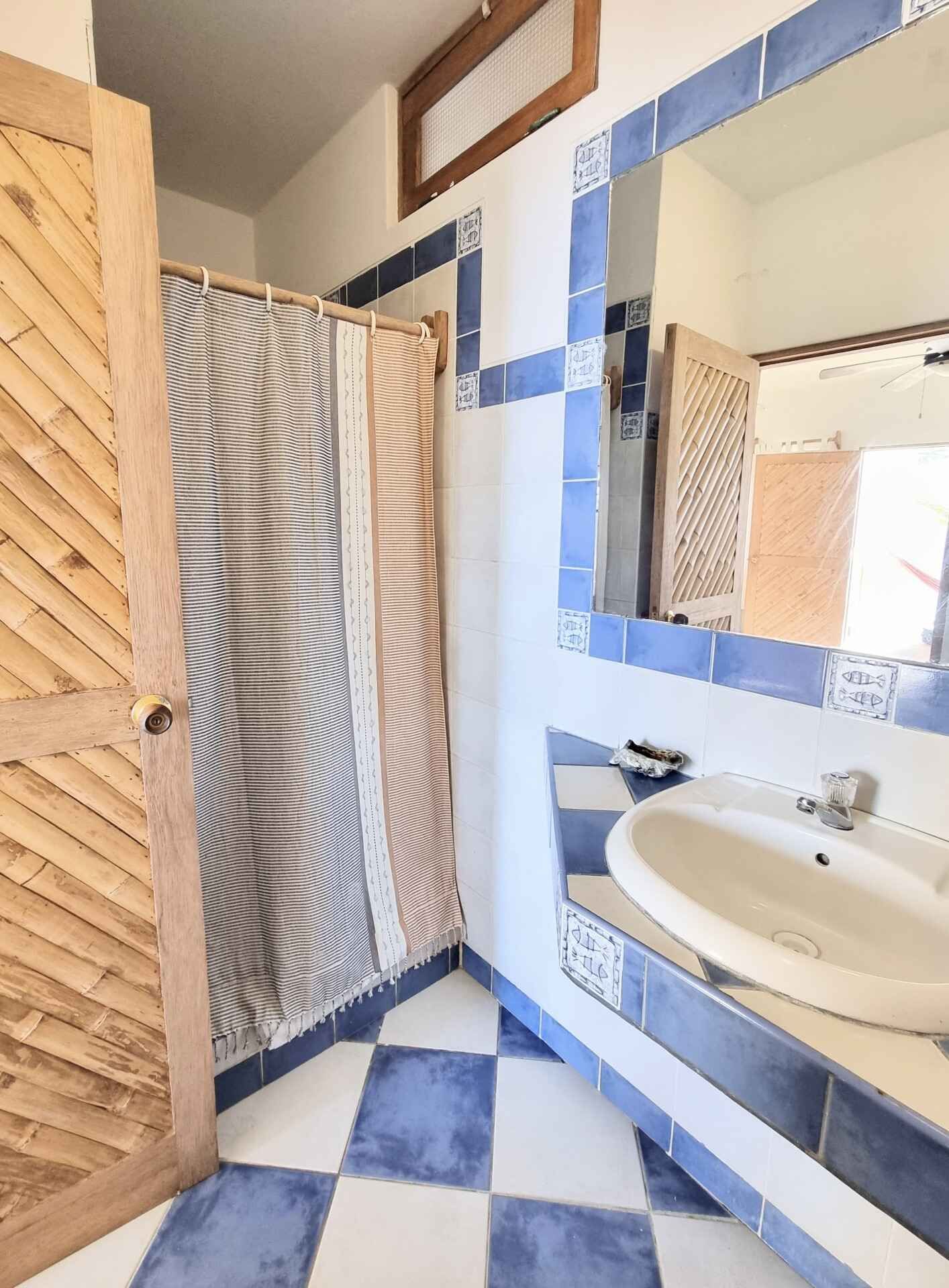 A bathroom with blue and white tiles and a sink