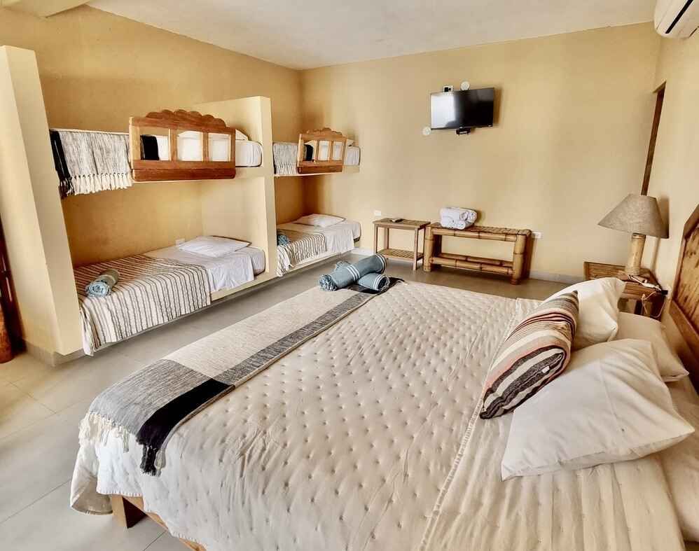 A hotel room with a large bed and three bunk beds.