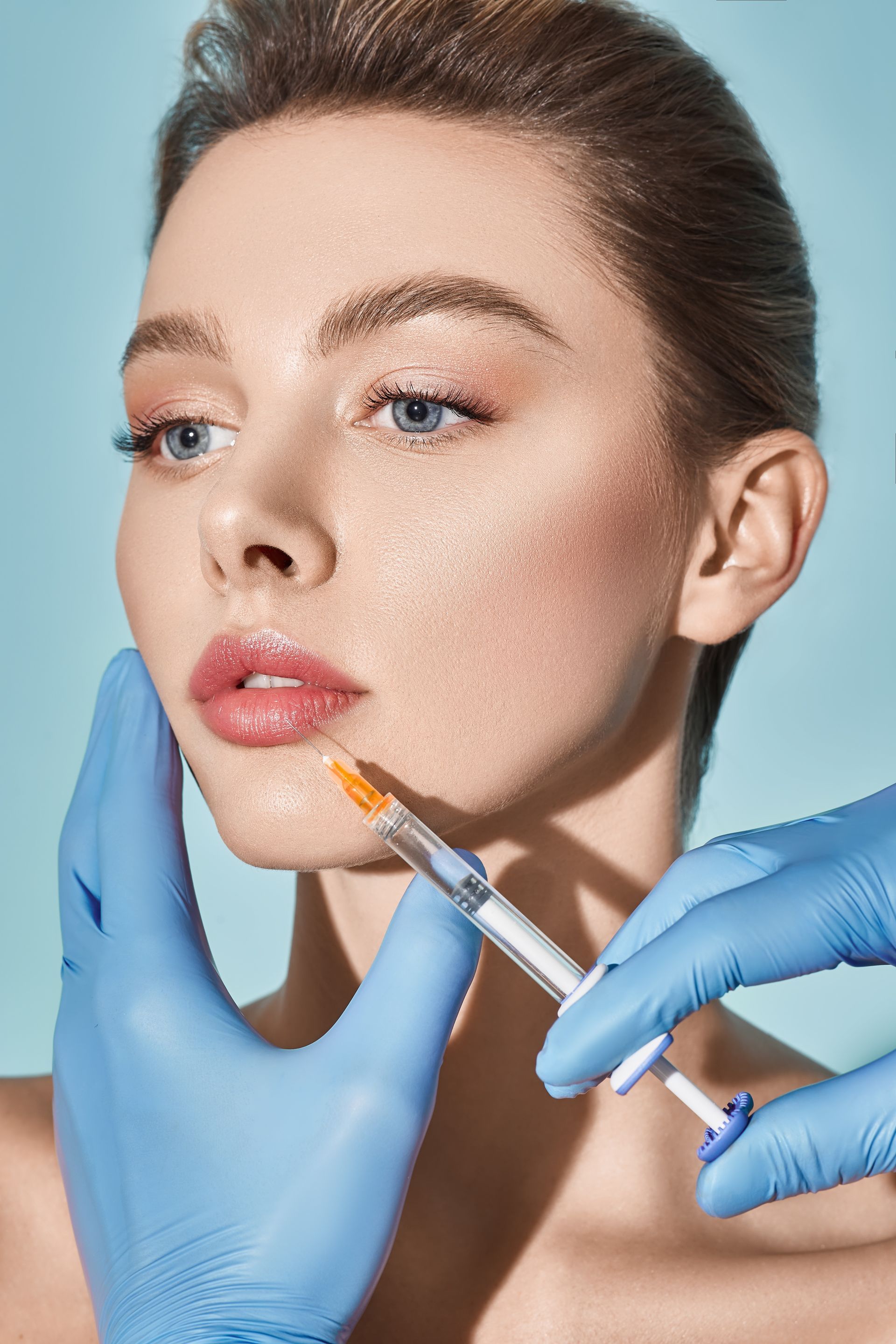 A woman is getting a botox injection in her face.