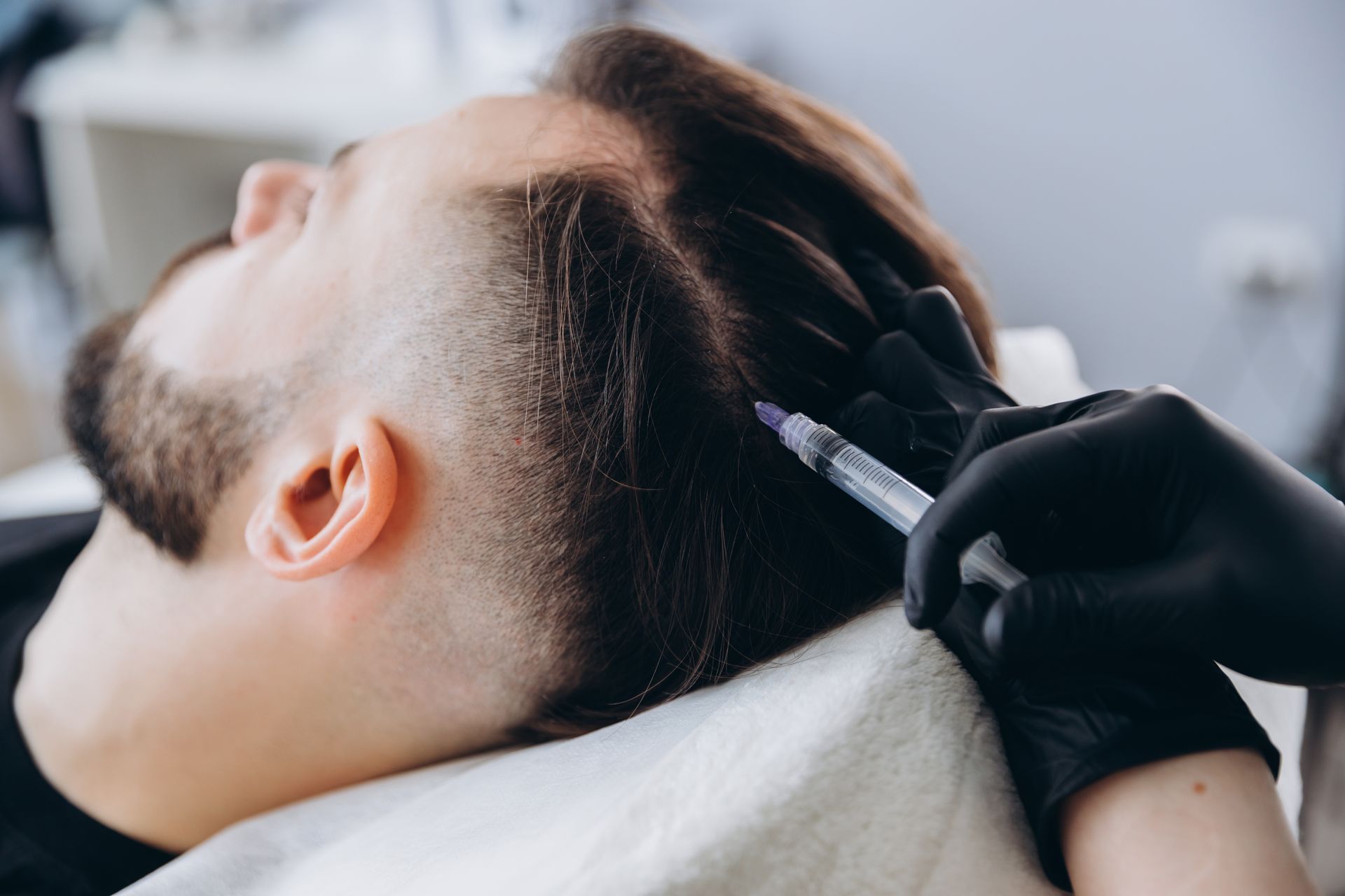 A man is getting an injection in his hair.