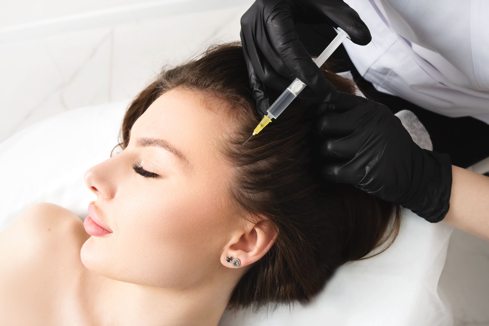 A woman is getting an injection in her hair.