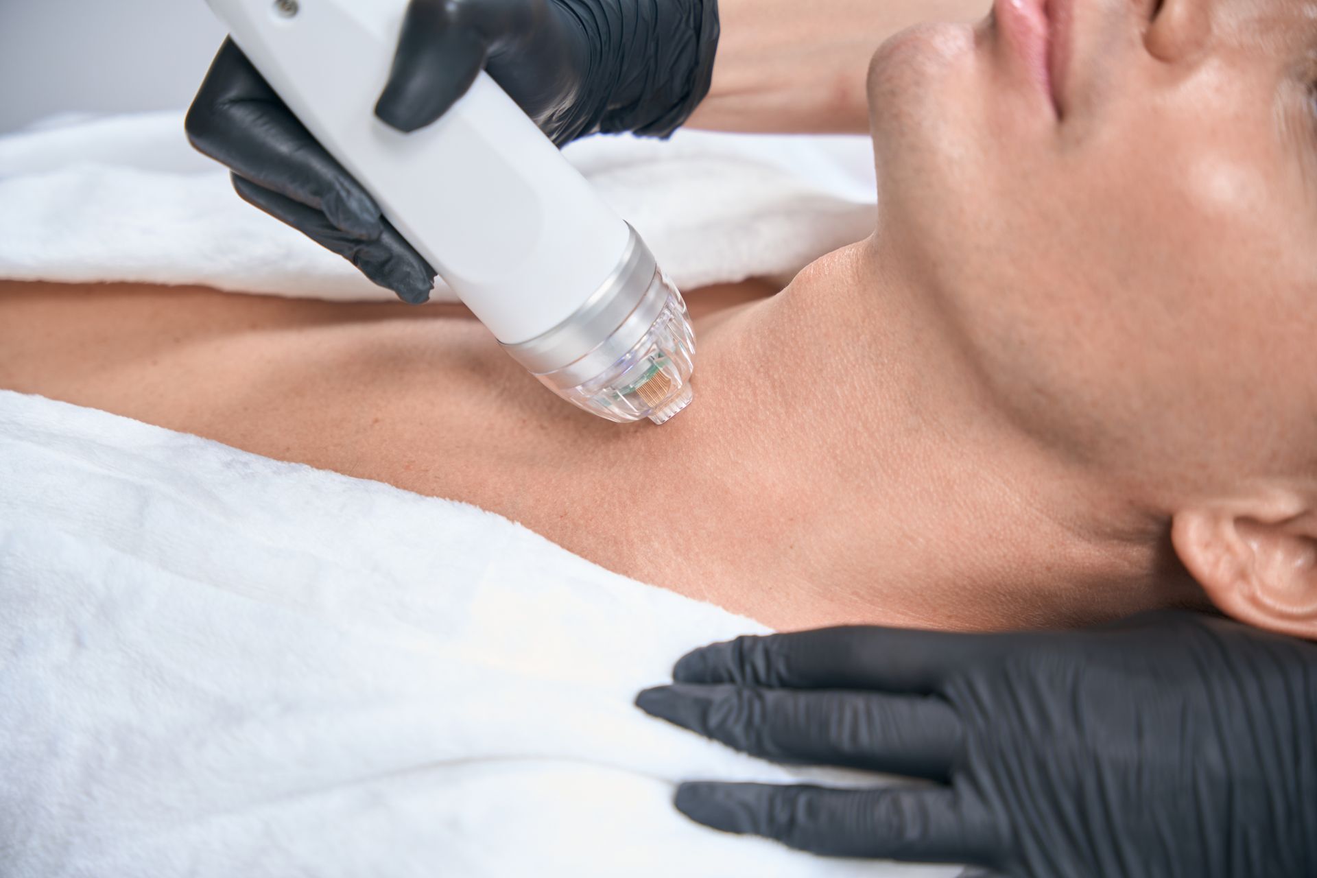 A man is getting a laser treatment on his neck.