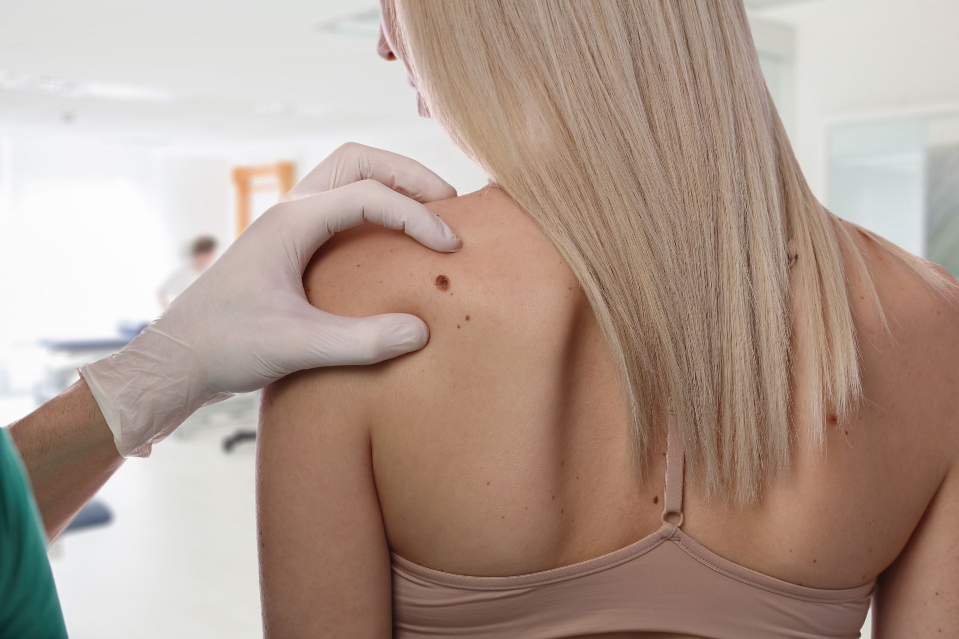 A woman is getting her skin examined by a doctor.