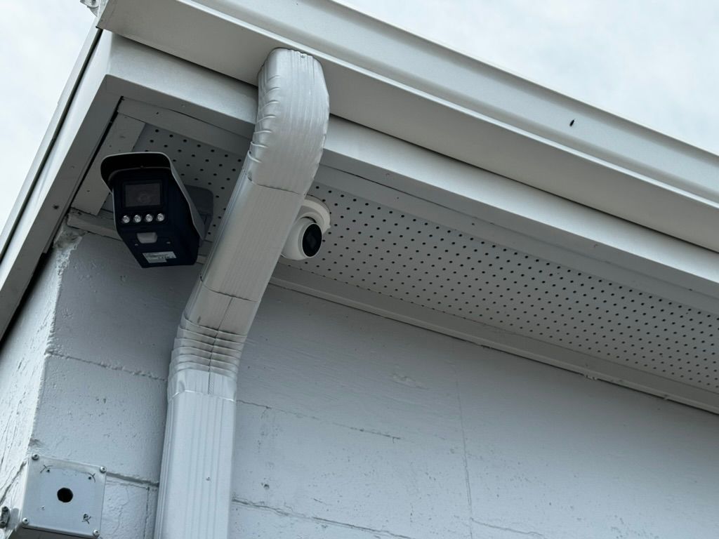 A security camera is mounted on the side of a building.