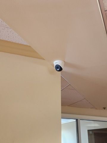 A security camera is mounted on the ceiling of a room.