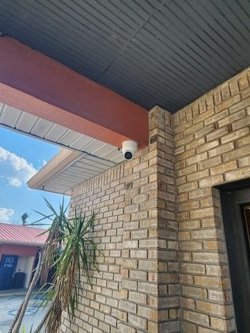 A brick building with a security camera on the side of it.
