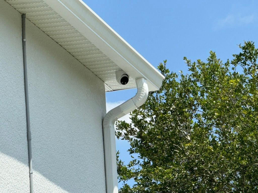 A white house with a camera on the side of it