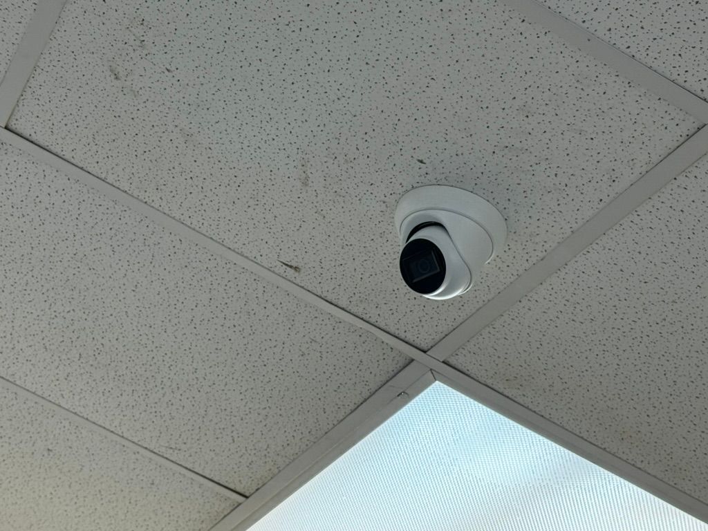 A security camera is mounted to the ceiling of a room.