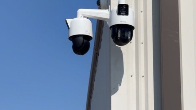 A security camera is mounted on the side of a building.