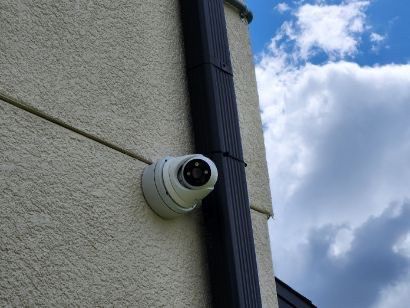 A security camera is mounted on the side of a building.