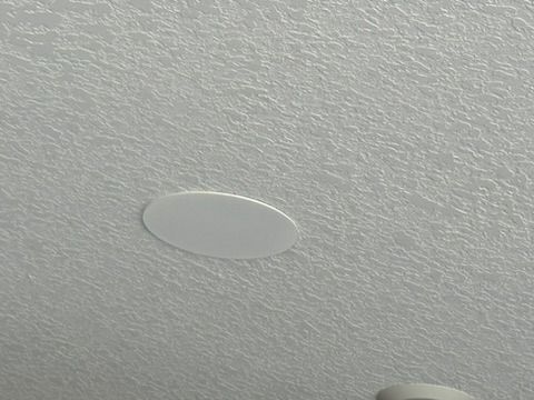 A white circle is sitting on top of a white ceiling.