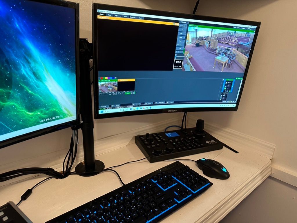 A computer desk with two monitors and a keyboard