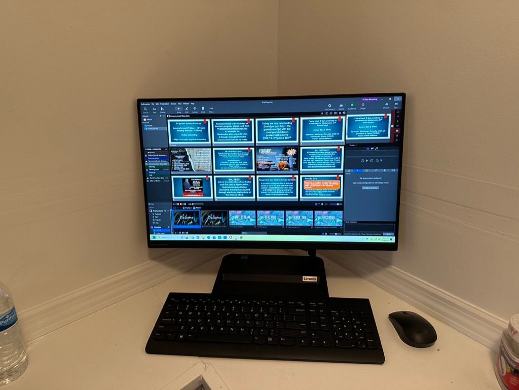 A computer monitor is sitting on a desk next to a keyboard and mouse.