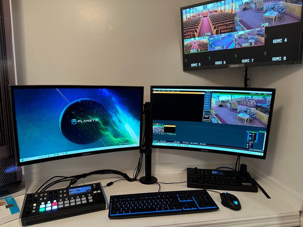 A computer desk with two monitors and a keyboard
