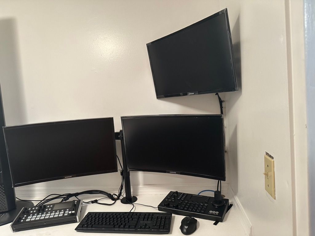 A computer desk with two monitors , a keyboard , and a mouse.