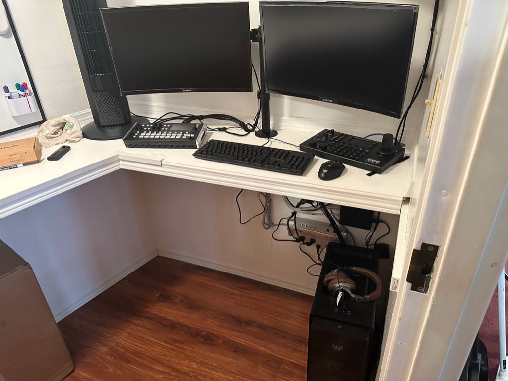 A computer desk with two monitors and a keyboard
