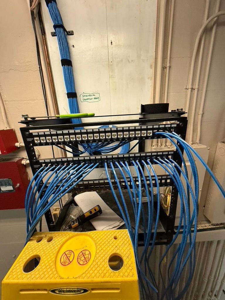 A bunch of blue wires are hanging from a wall next to a yellow stool.