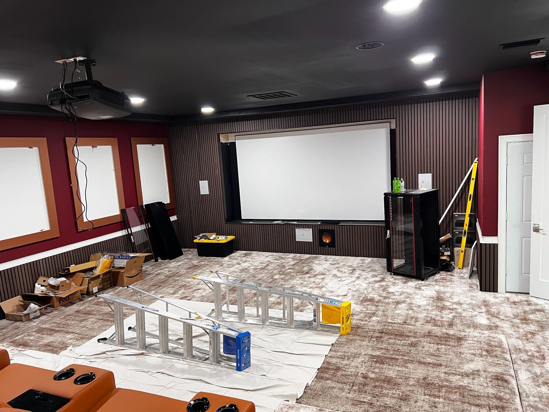 A home theater is being built in a basement with a projector screen.