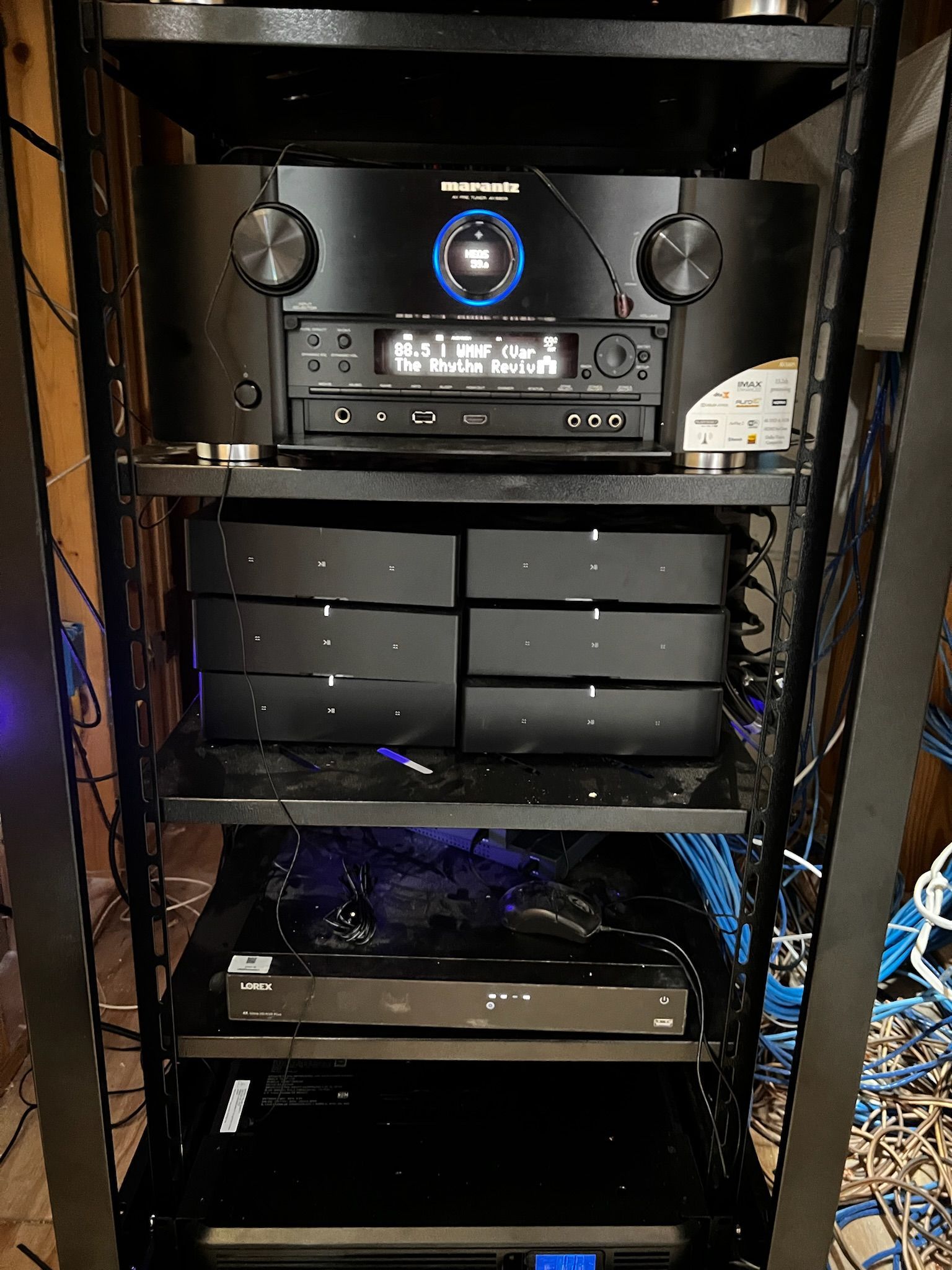 A stereo system is sitting on top of a rack in a room.