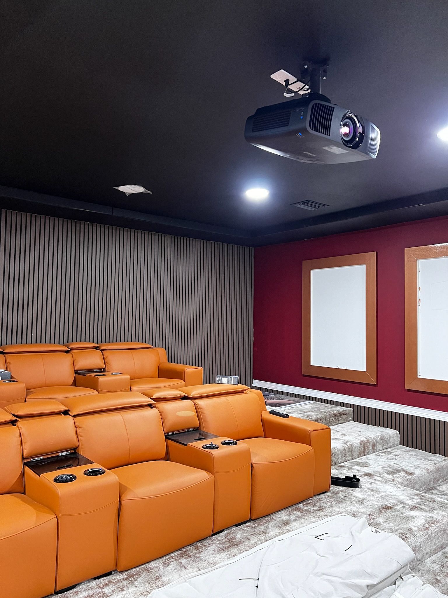 A home theater with an orange couch and a projector