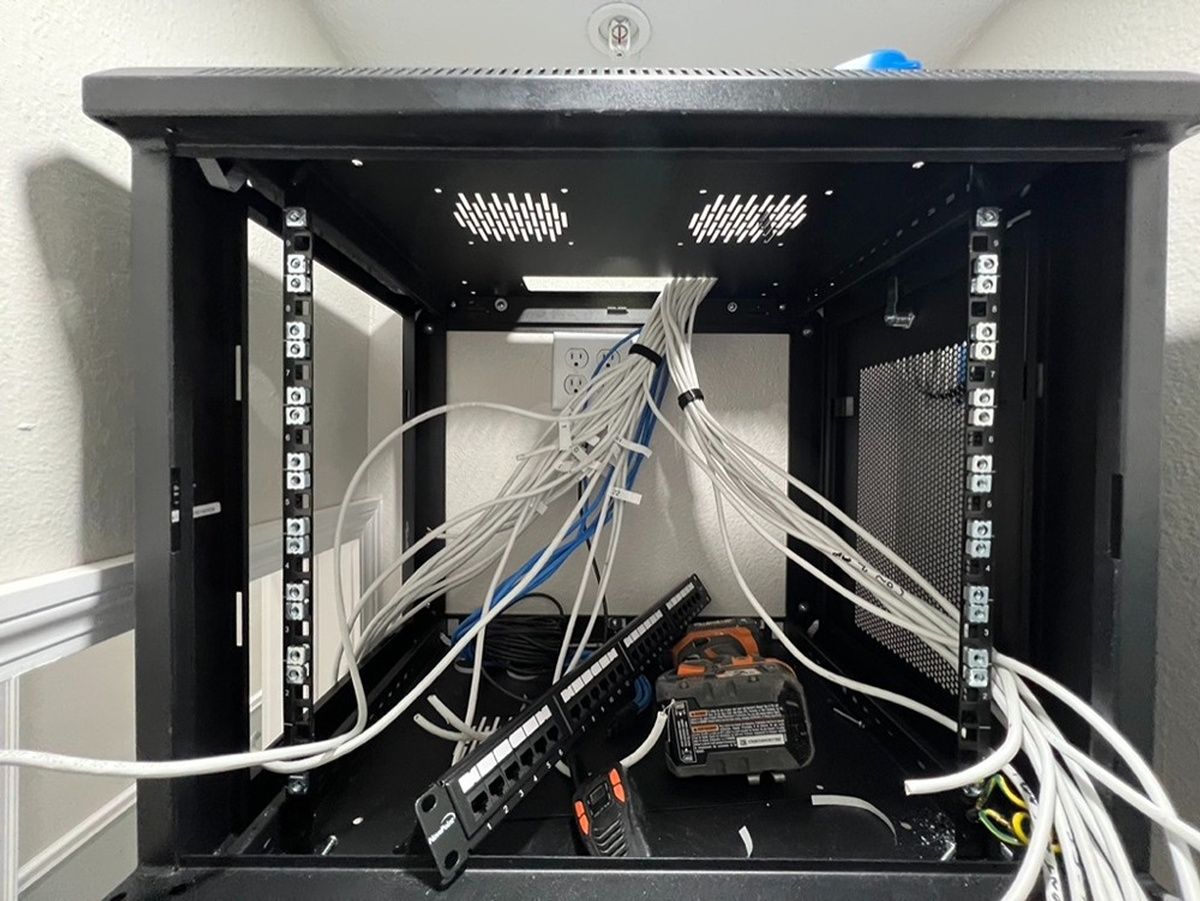 A server rack with a lot of wires coming out of it