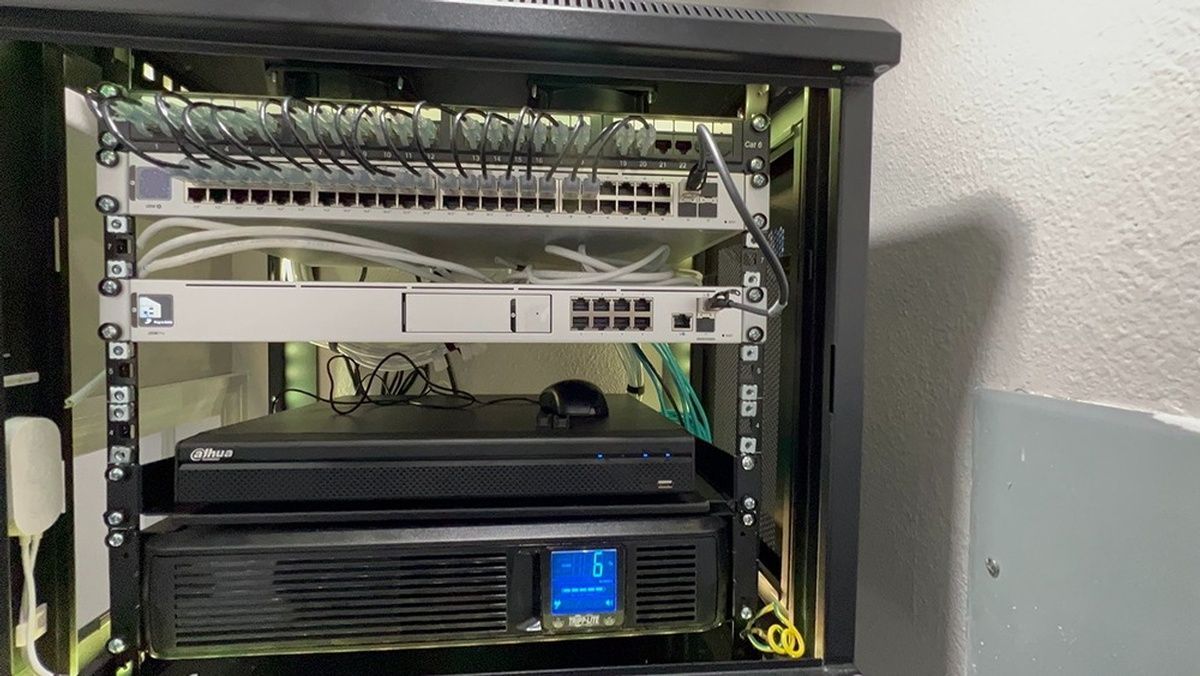 A server rack with a lot of wires coming out of it.