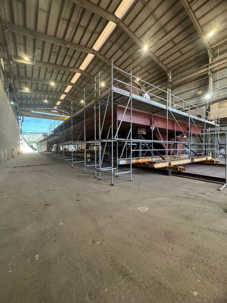 A large ship is being built in a warehouse with scaffolding — T & T Scaffolding in Gordonvale, QLD