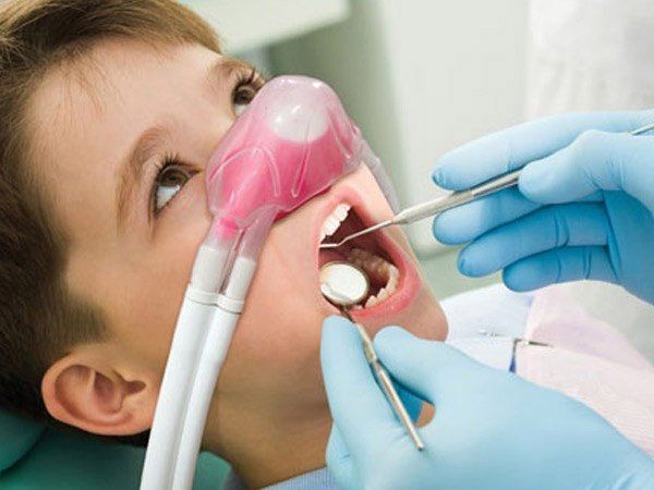 un ragazzo sta ricevendo un trattamento dentale da un dentista .