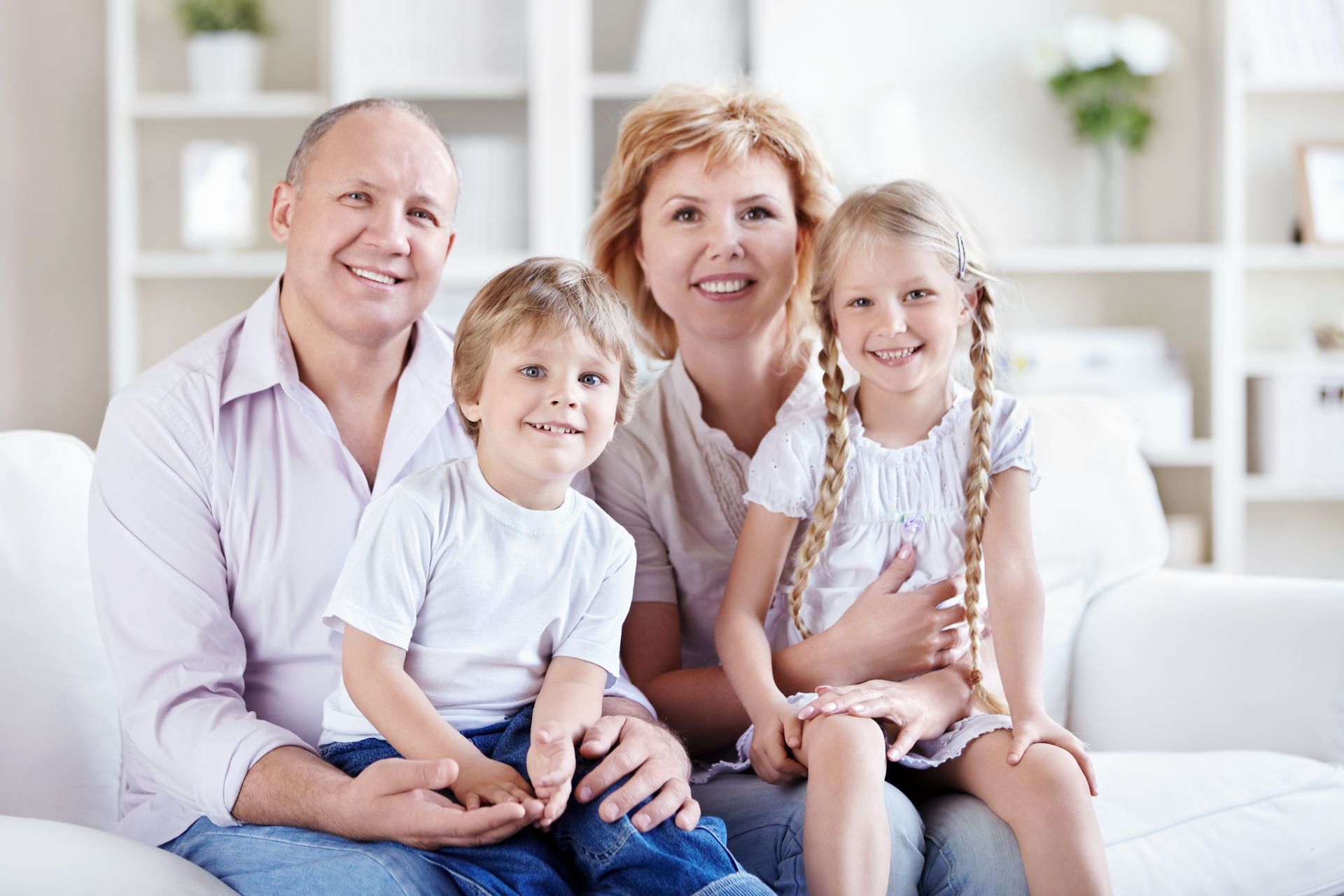 Una famiglia posa per una foto seduta su un divano.