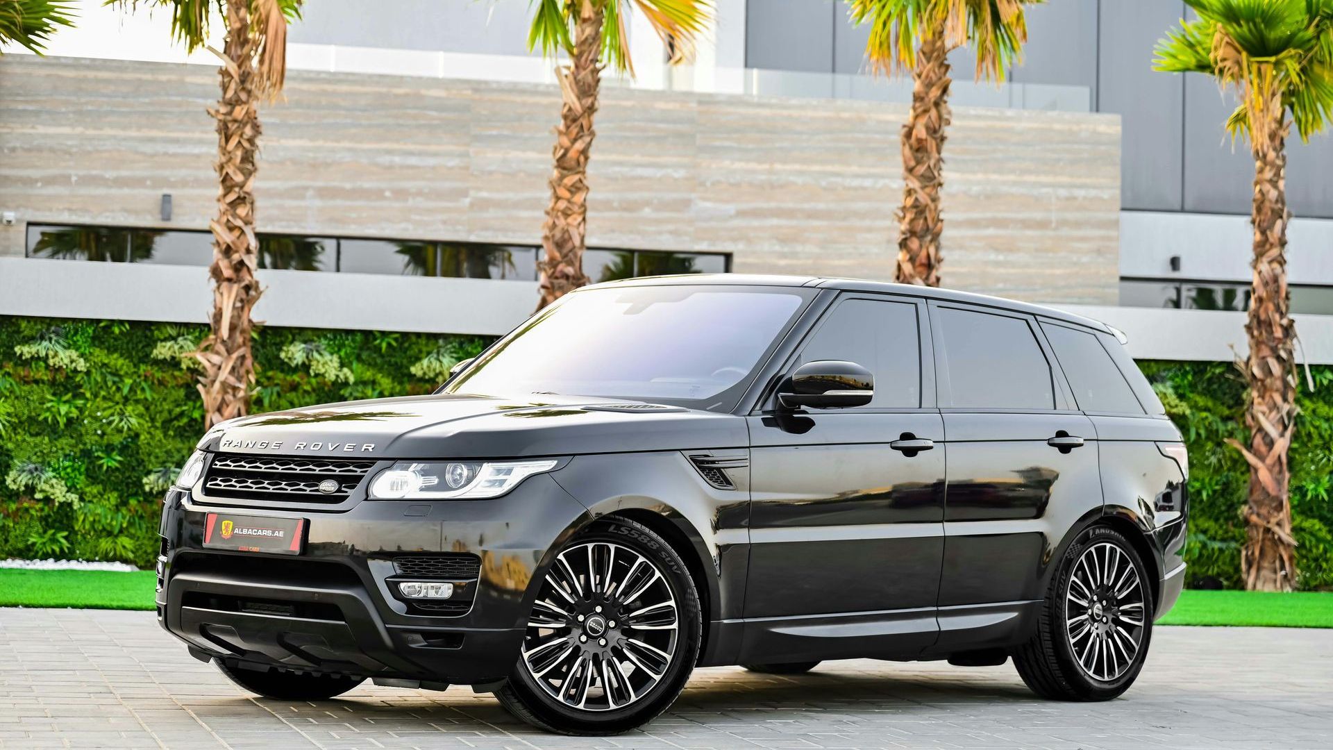 a white range rover is parked in a parking lot