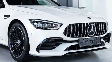 A white mercedes benz amg gt63 s is parked in a garage.