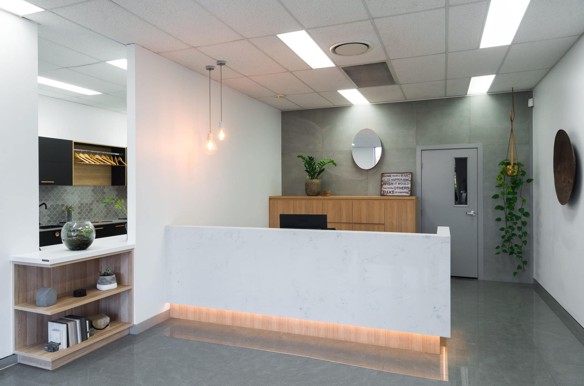 Modern Office Reception Area With a White Desk, Light Wood Accents, and Gray Walls — Akyrah Kitchens in Gympie, QLD