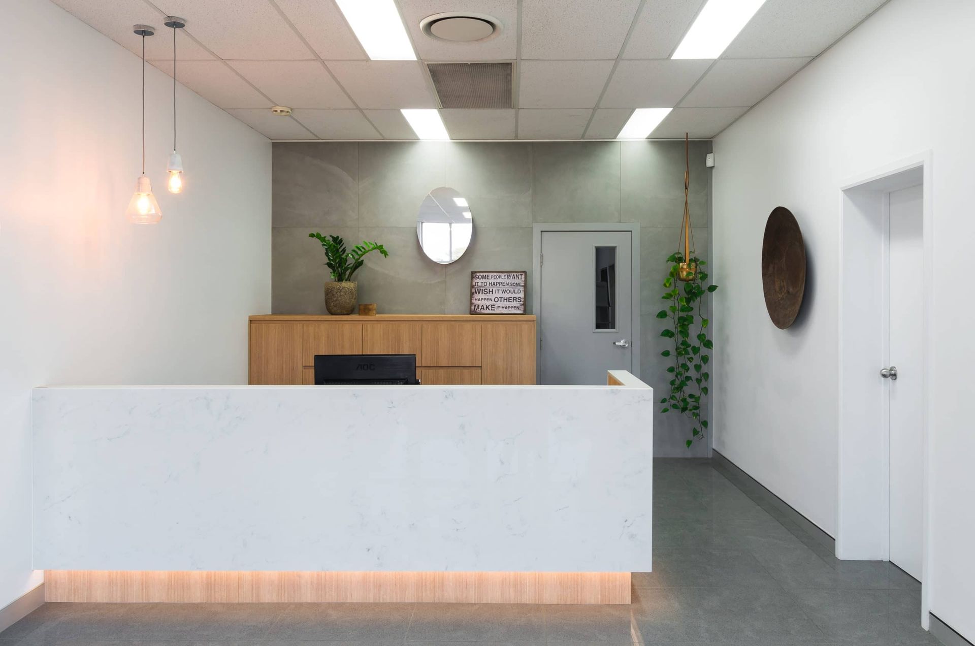 Modern Office Reception Area With White Desk, Wooden Accents, and Decorative Plants — Akyrah Kitchens in Gympie, QLD