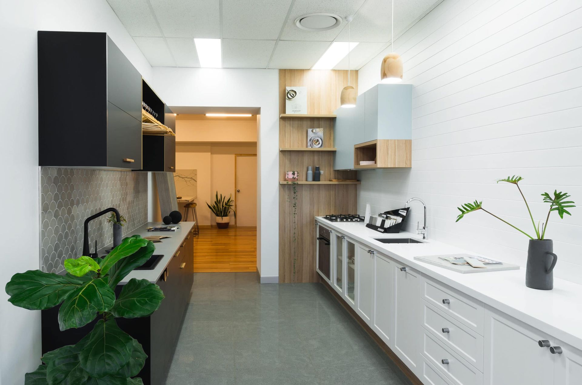 Modern Kitchen With Black and White Cabinets, White Brick Wall, and Green Plant — Akyrah Kitchens in Gympie, QLD