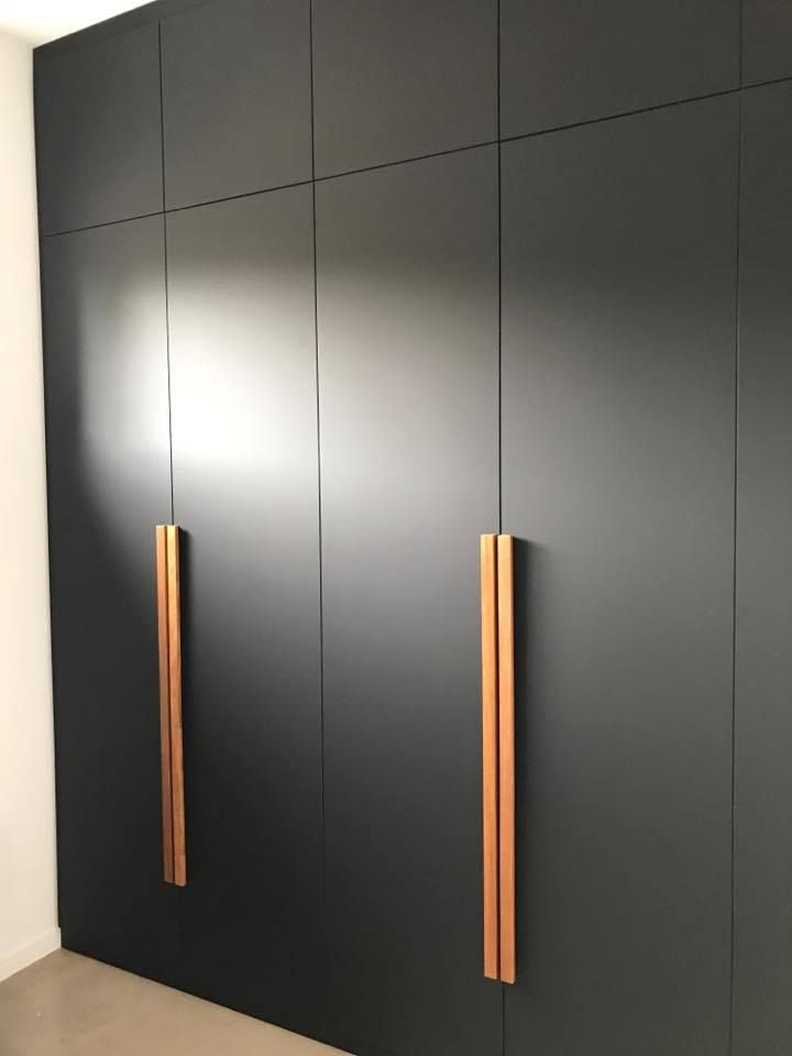 Black Closet Doors With Vertical Copper-colored Handles in a Room — Akyrah Kitchens in Gympie, QLD