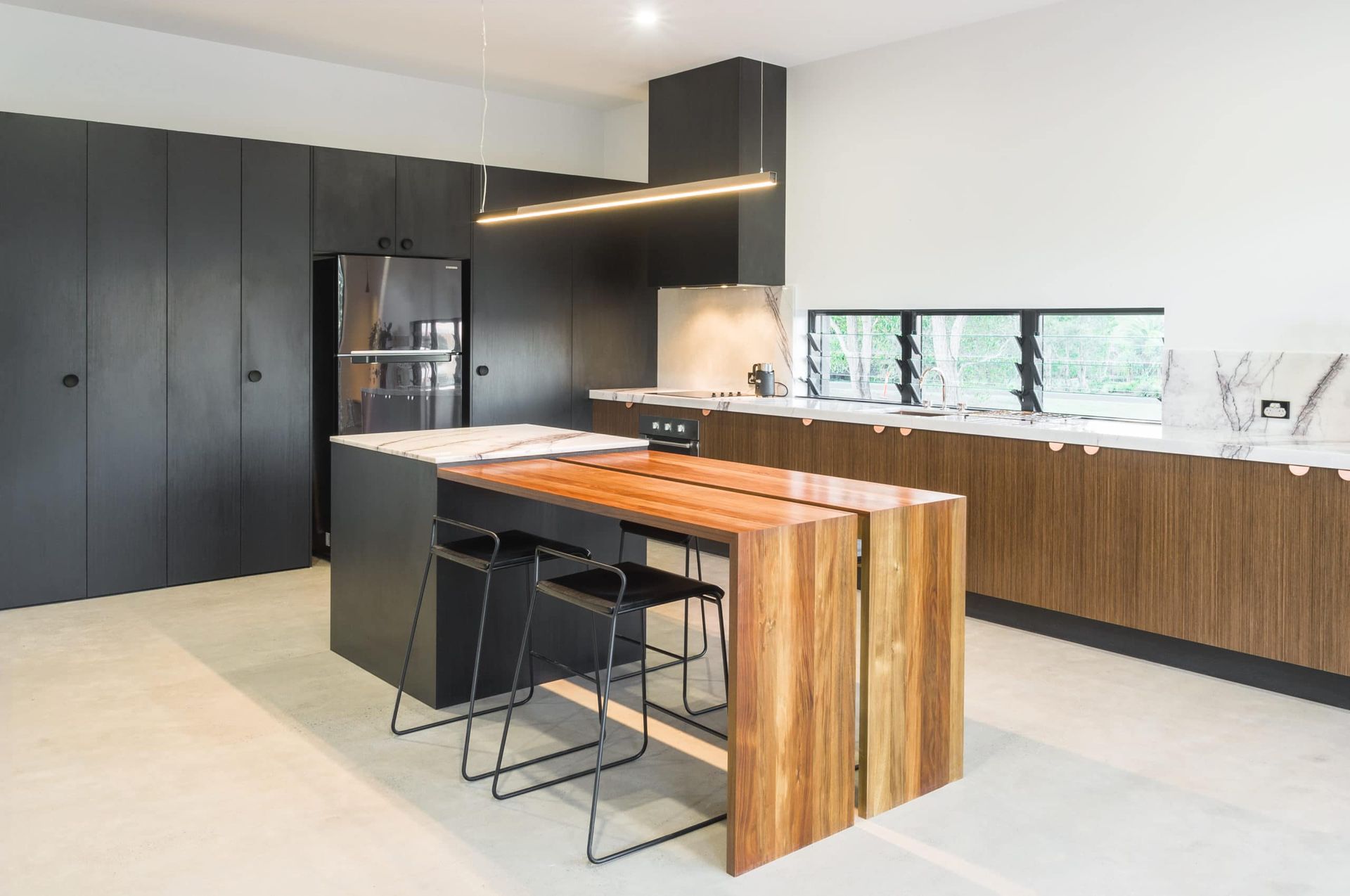 Kitchen With Black Cabinetry, Wood Island With Seating, and Stainless Steel Appliances — Akyrah Kitchens in Gympie, QLD
