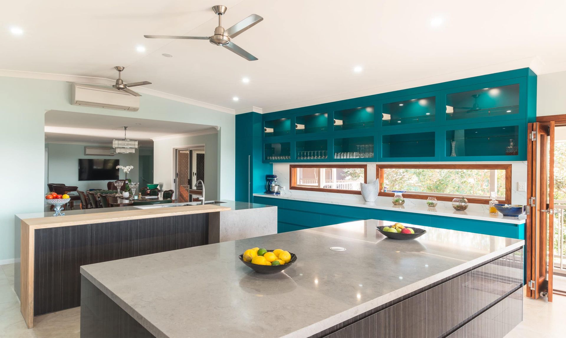 Modern Teal Kitchen With a Large Island, Windows, and Two Ceiling Fans — Akyrah Kitchens in Gympie, QLD