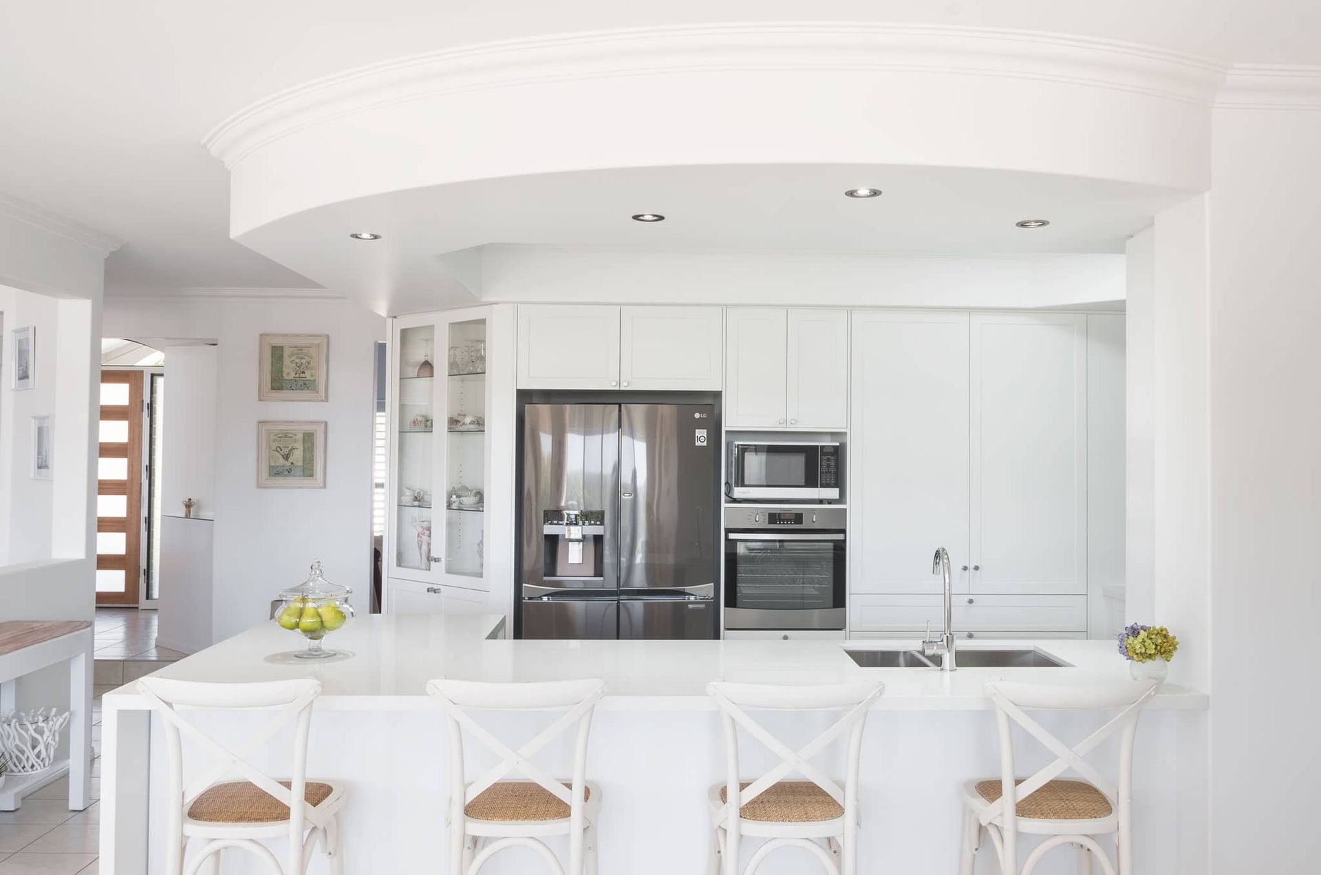 White Kitchen With Island Seating, Stainless Steel Appliances, and Built-in Cabinetry — Akyrah Kitchens in Gympie, QLD