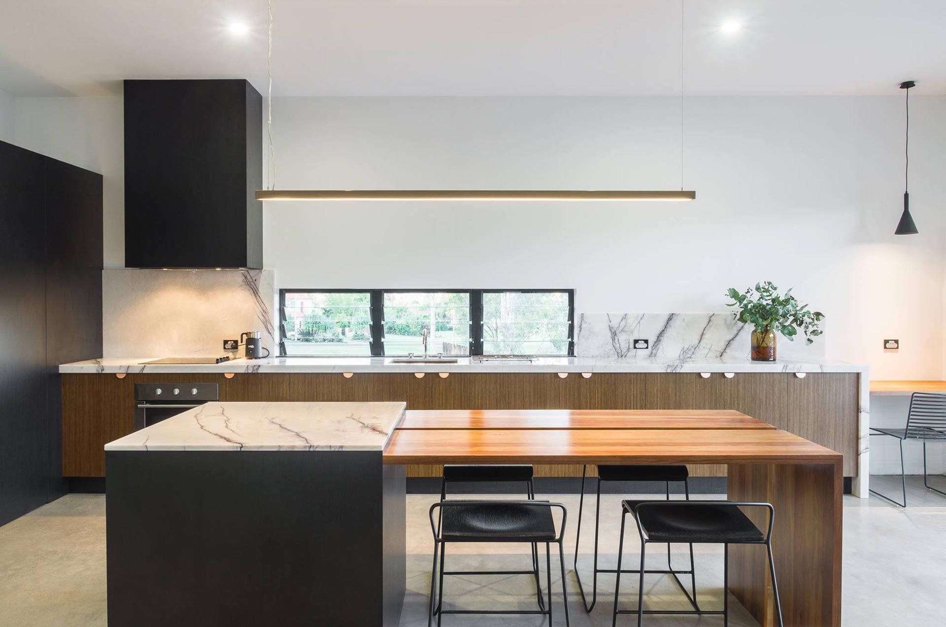 Kitchen With Island, Two Chandeliers, Steel Refrigerator, and Three Woven Bar Stools — Akyrah Kitchens in Gympie, QLD